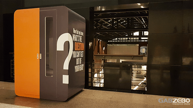 Orange and gray branded video booth installed beside an indoor balcony