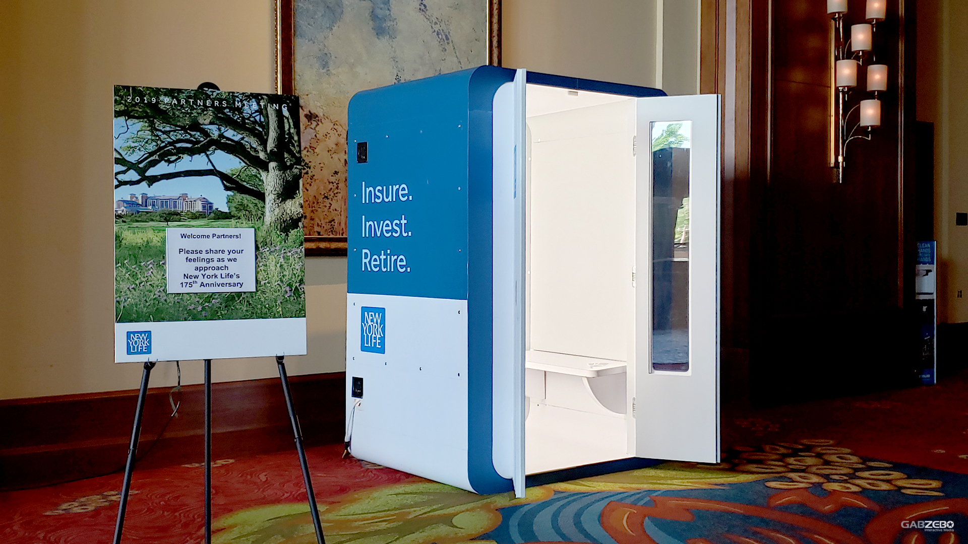 Blue and white branded video booth beside an event display